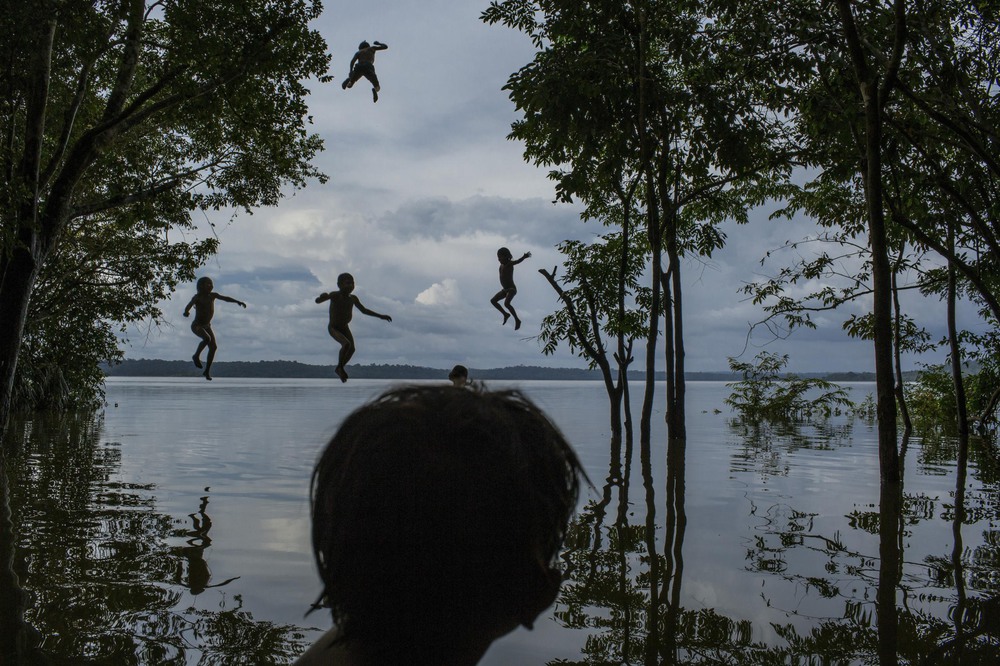 Daily Life 2nd place. Indigenous Munduruku children play in the Tapajos river in the tribal area of Sawre Muybu, Itaituba, Brazil.

The tribesmen of the Munduruku, who for centuries have sanctified the Tapajos River on which their villages sit, are fighting for survival. Brazil’s government plans to flood much of their land to build a $9.9 billion hydroelectric dam, the Sao Luiz do Tapajos, as part of a wider energy strategy across the Amazon rainforest.