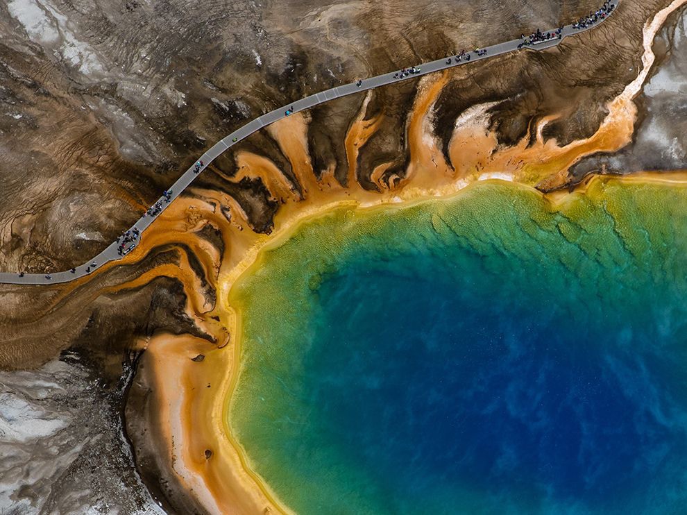 1 Over Yellowstone. Photograph by Eric Smith.    "The day Your Shot member Eric Smith first walked the path around Yellowstone National Park’s Grand Prismatic Spring, he made an addition to his bucket list: photographing the spring from the air. “I made that dream a reality as I took off in a helicopter from Bozeman, Montana, and flew to the Midway Geyser Basin [where Grand Prismatic is located] to get the 50-megapixel shots I had always seen in my mind,” he writes. “It was even more spectacular than I could have imagined ... The final composition juxtaposes humanity with one of America's most incredible natural treasures.”