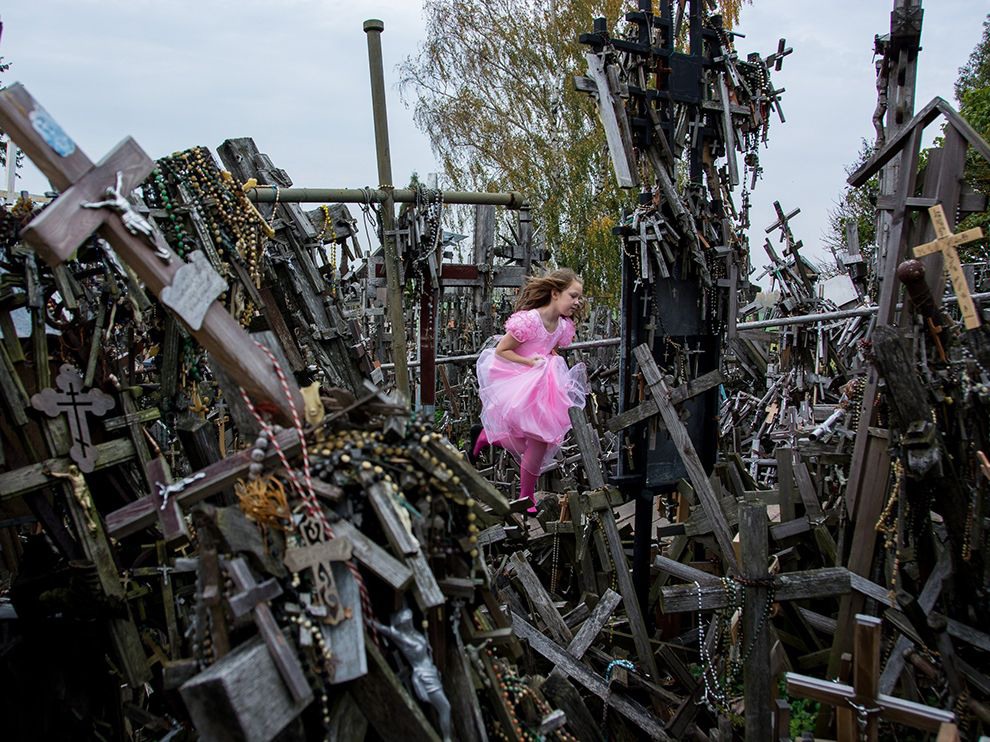 24 Hill of Crosses. Photograph by Hideki Mizuta.     "Thousands of religious tributes—said to have first appeared in a peaceful show of resistance to foreign oppression—are amassed on the Hill of Crosses in Siauliai, Lithuania. “Many people pray for God and [mourn] the death of people killed by war,” writes Your Shot member Hideki Mizuta. “When I visited here, a girl ran through ... It was a strange sight.”