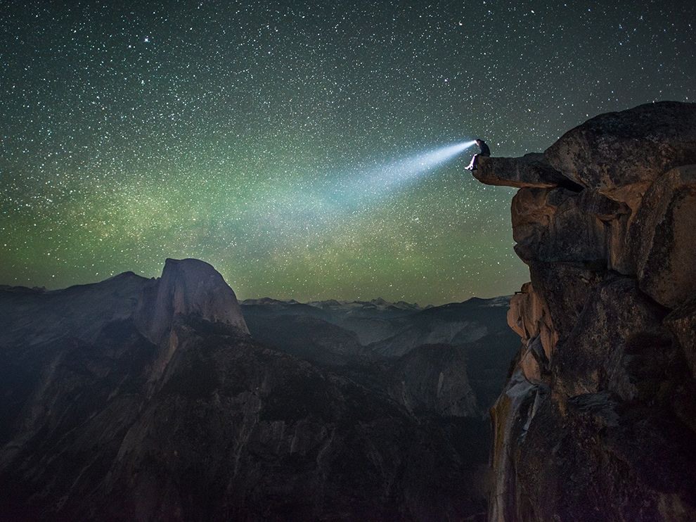 31 The Best Seat in Yosemite. Photograph by Christian Fernandez.     "Under a blanket of stars, a man takes in the landscape of Yosemite National Park from the edge of the Diving Board, a rock formation at Glacier Point."
