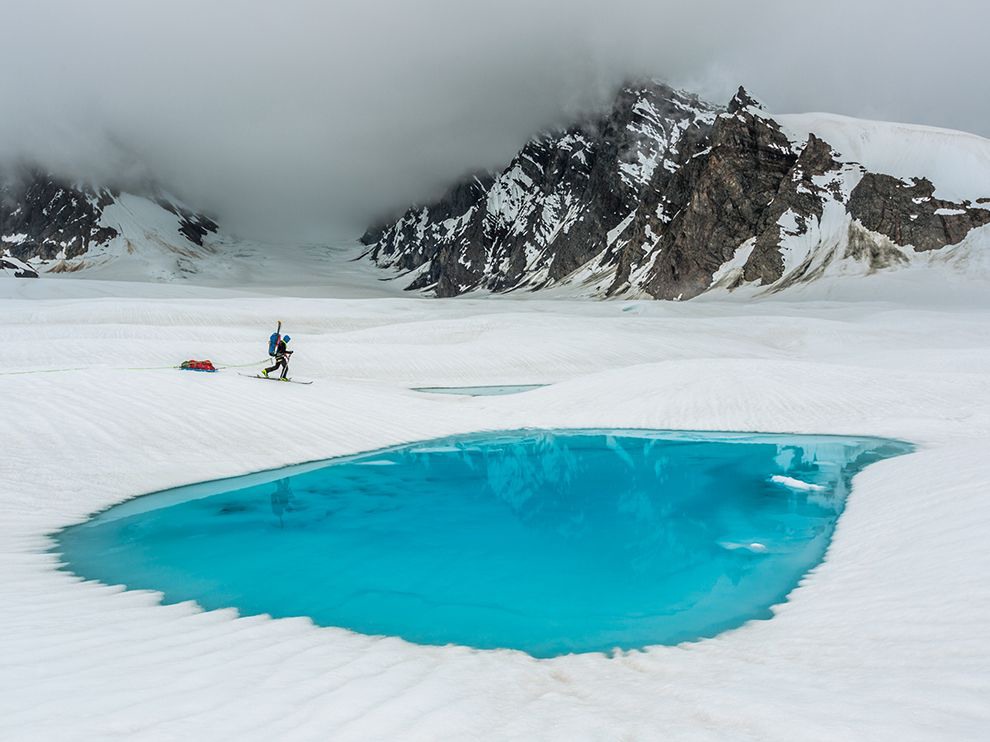 30 A Tranquil Trek. Photograph by Aaron Huey. Gliding toward one of the hundreds of untouched mountainsides in the high backcountry of Denali National Park in Alaska, a climber skis past sapphire pools atop upper Ruth Glacier.