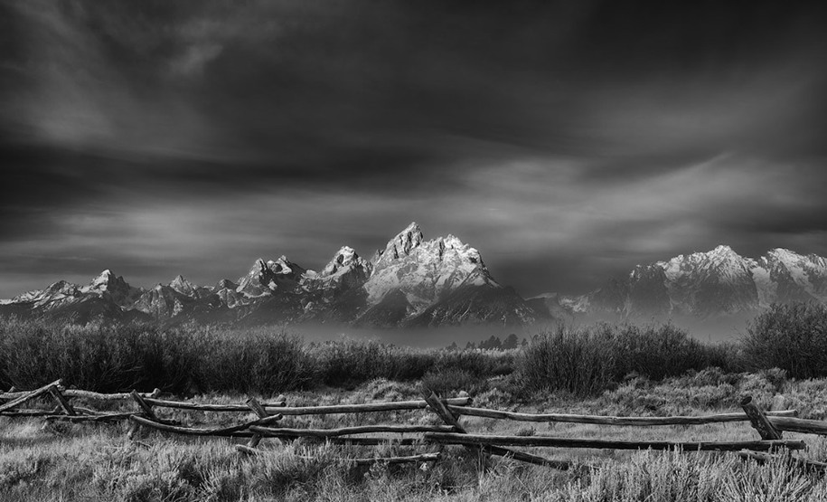13 Runner-Up, Future Publishing Special Award: Ashish Varma – Autumn Fog over Grand Tetons, near Jackson Hole, Wyoming. "Image captured on a bitterly cold morning with the temperature around -10C with overnight snow on the Tetons and frost on the ground. Lingering fog revealed occasional glimpses of the Grand Teton so timing was critical to capture the image at just the right moment for best combination of fog and visibility. Black-and-white conversion adds an ethereal quality to the image and highlights the dramatic layers of fog."