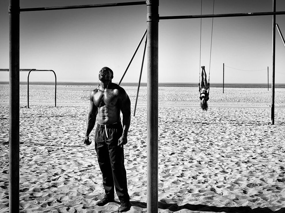 11 Sweat and Swing. Photograph by Dotan Saguy. Muscle Beach in Santa Monica, California, has been a popular spot for fitness fanatics since it was first built in the 1930s. It’s also one of Your Shot member Dotan Saguy’s favorite places to photograph “because of the layering opportunities as well as the opportunities to compose ... frames within the frame.” Saguy had been alerted to the main subject of this image and was intrigued by the intense facial expressions the man made during his workouts. “I had been trying many different ideas there,” Saguy writes. “One day [I] was lucky enough to bump into this particular situation which had a strong subject in the foreground and its complete opposite in the background, both of which were framed by the bars.”