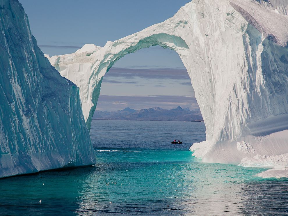 11 Bridge Over Icy Water. A small Zodiac touring boat provides scale for this iceberg off the coast of Greenland. Photograph by Lorraine Minns.