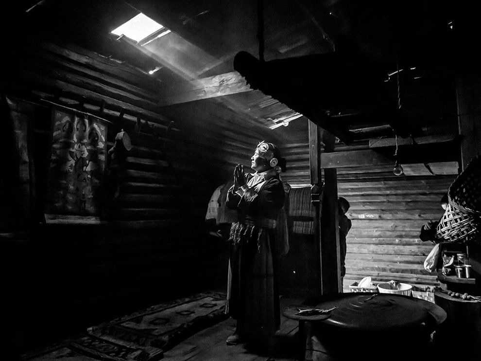 17 "Standing in the Light". Photograph by Christopher Martin. In the northern reaches of China’s Yunnan Province, in the front range of the Himalaya, many of the people living in the small towns and villages are ethnic Tibetan. Here, Your Shot member Christopher Martin gets a glimpse into one of these traditional Tibetan homes, catching a moment of prayer.